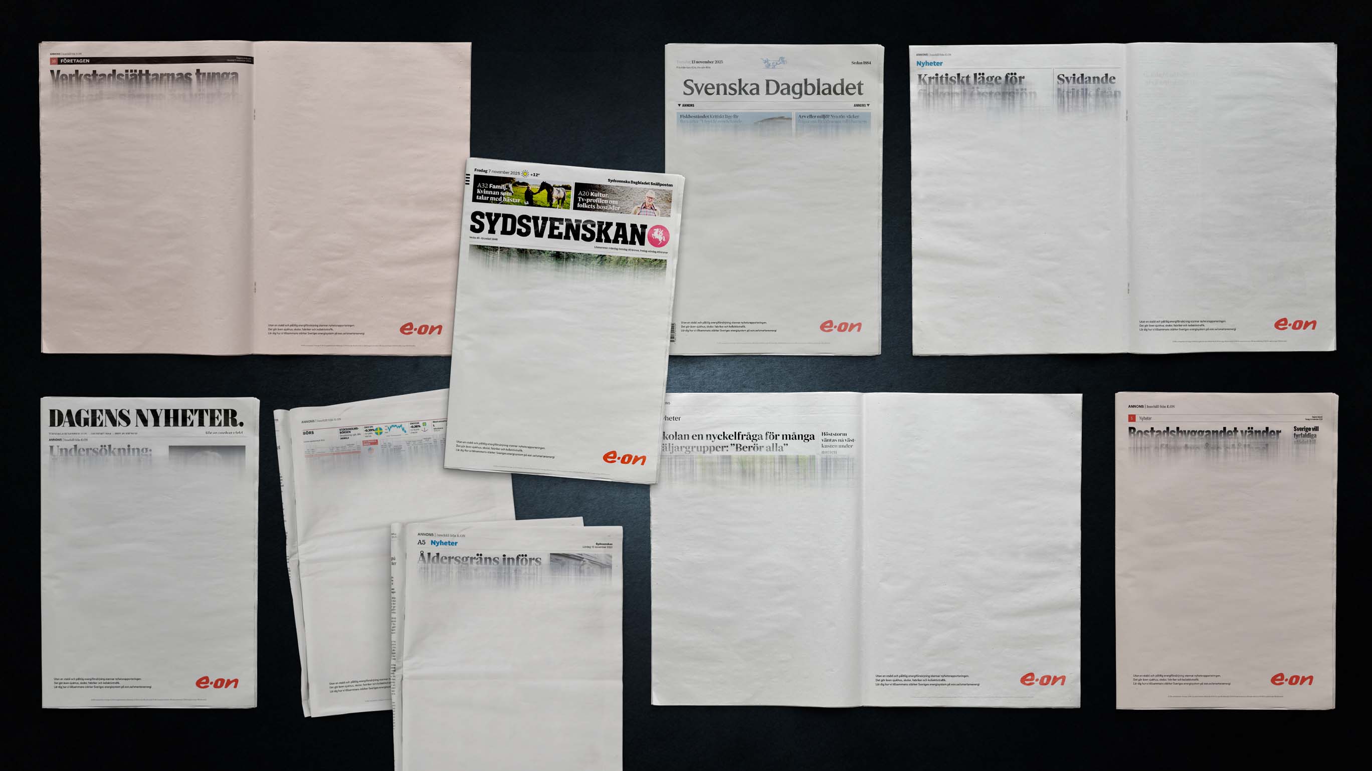 Several blank newspaper pages with only faded headlines and the e.on logo in the bottom right corner on a black background.
