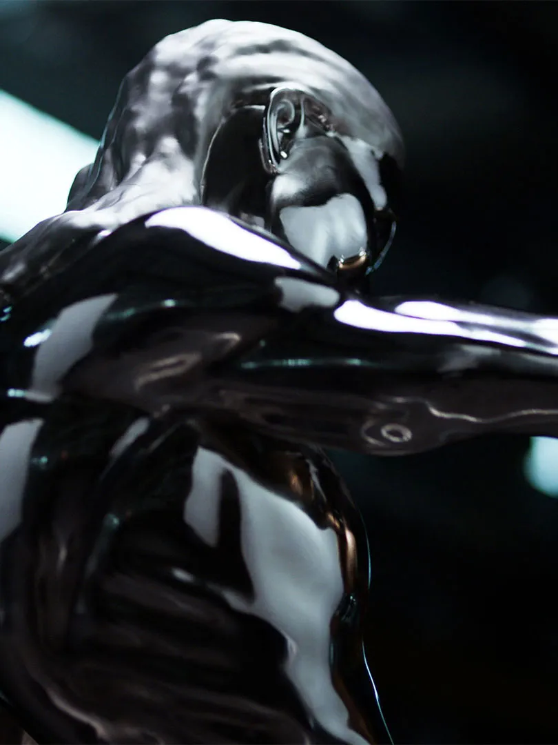 Close-up of a shiny, metallic humanoid sculpture with smooth reflective surfaces and an abstract form.