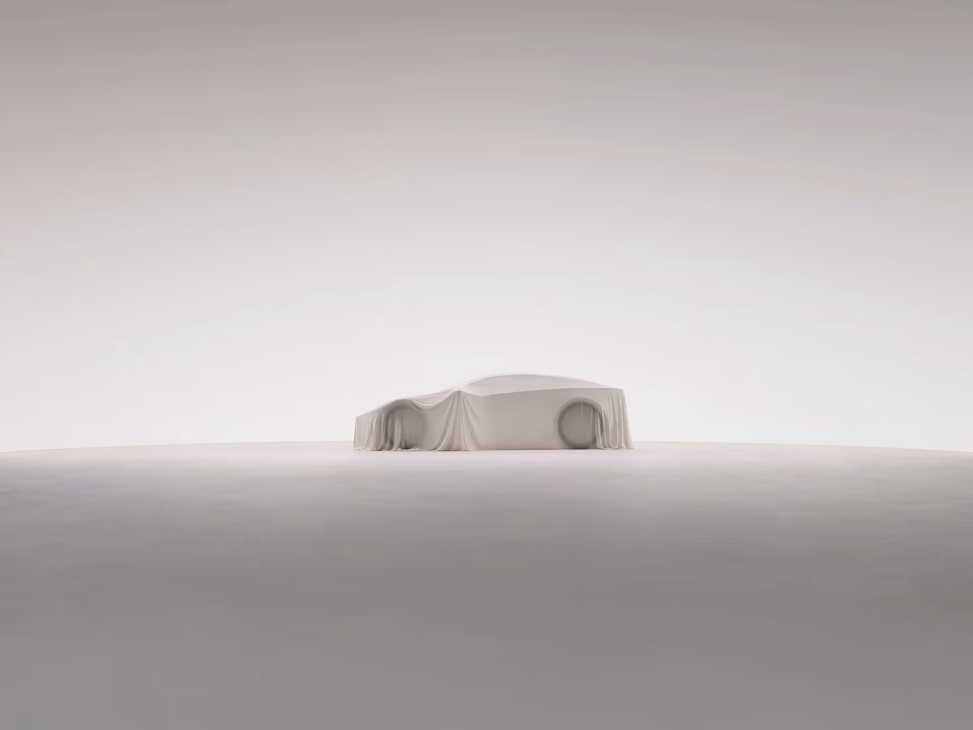 Side view of a car covered with a white cloth on a smooth, light-colored surface in a minimalistic setting.